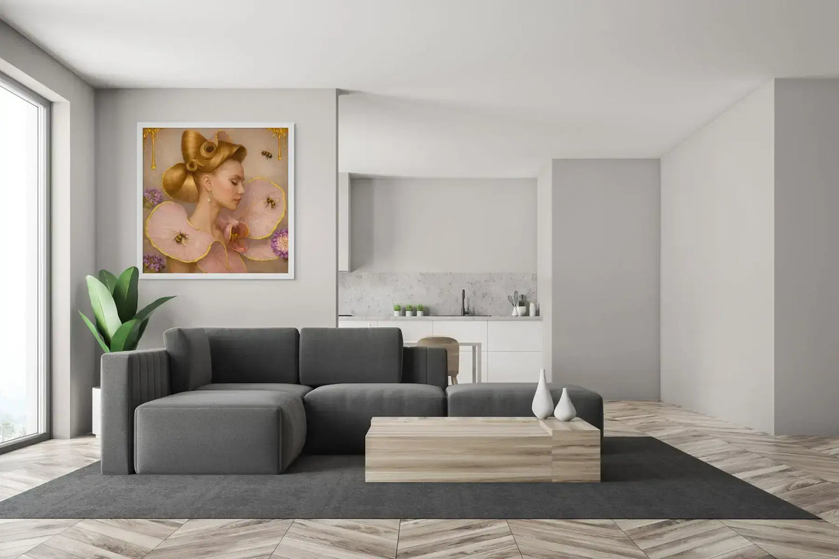 Luxury gold leaf portrait painting Gilded Honey I displayed in a white frame above a dark grey sectional sofa in a modern minimalist living room.